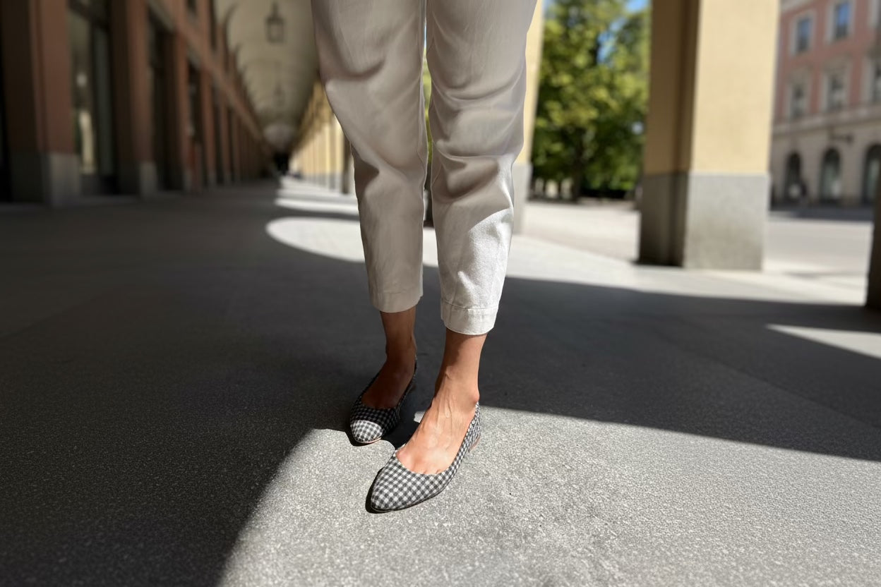Eine Frau im Archaden vom Hofgarten in München trägt Ballerinas aus Vichy-Loden, die aus einem hochwertigen Material gefertigt sind.